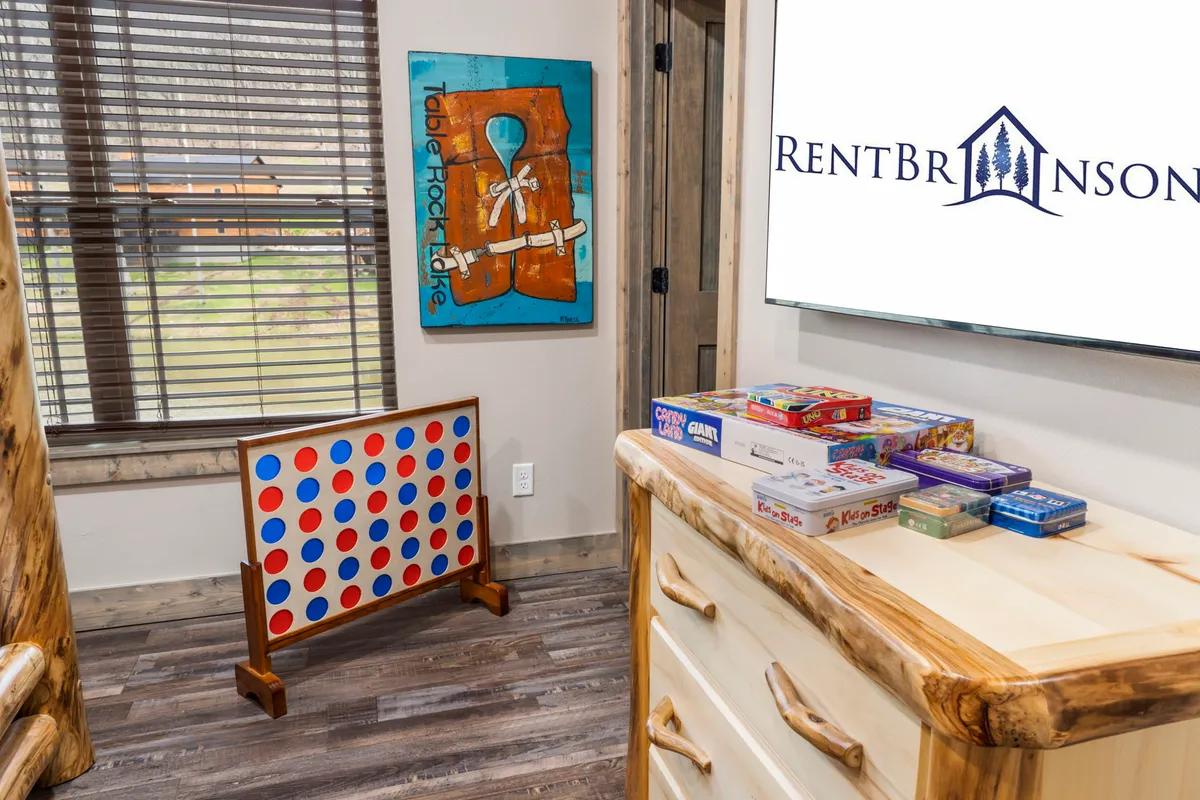 A playful family game area, centered around a Connect Four game and a variety of classic board games, complemented by colorful artwork and wooden furniture. The setting radiates a lighthearted, nostalgic energy ideal for game nights and family bonding.