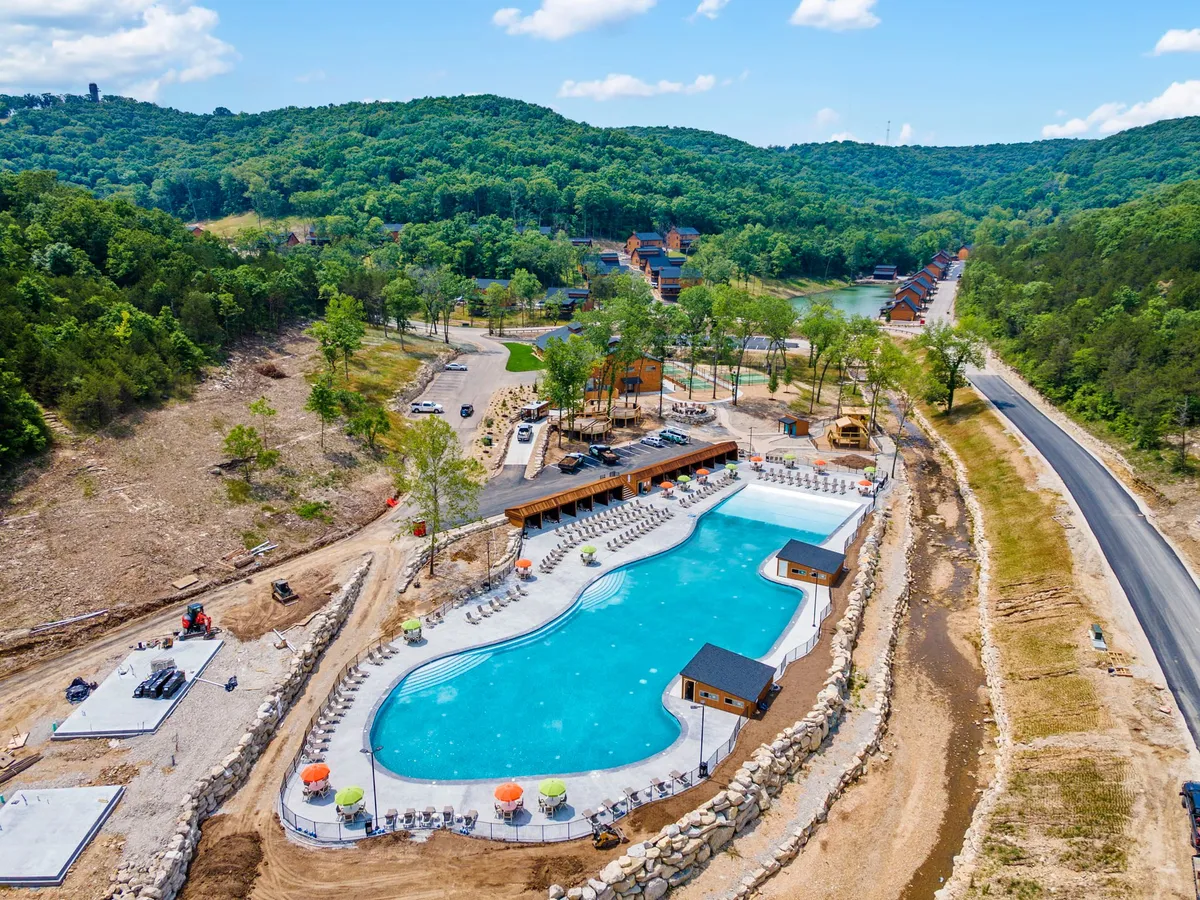 A bright, inviting swimming pool scene with poolside lounge chairs, surrounding greenery, and stylish cabana structures. The mood is relaxed, suggesting both fun and rest for the whole family.